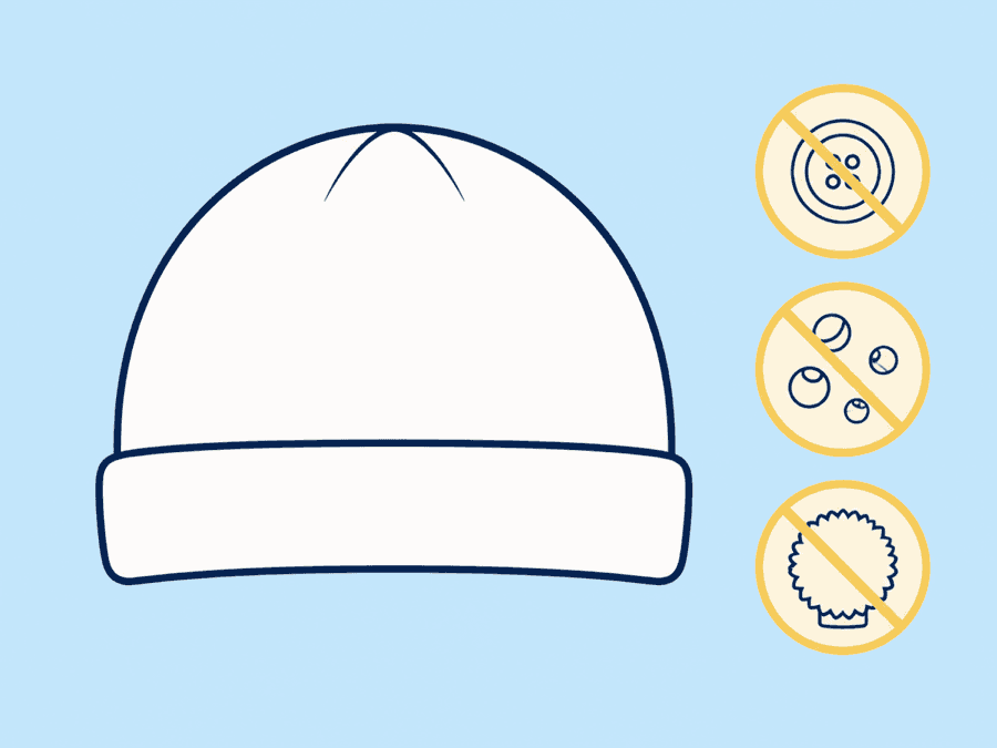 Diagram of a plain baby hat with crossed-out decorative buttons, beads and pom-poms beside it