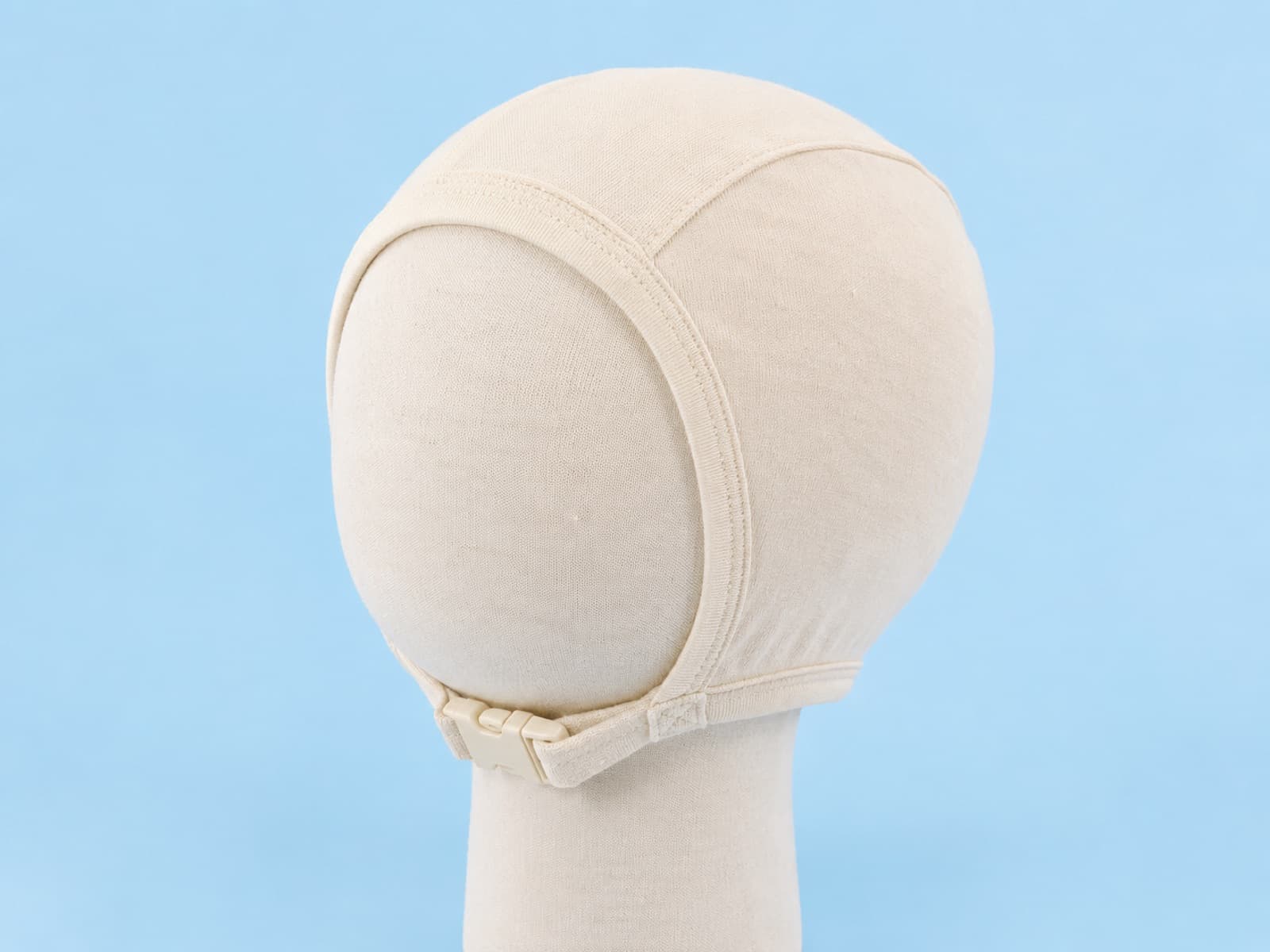 Undyed ecru cotton baby bonnet with a fine visible weave