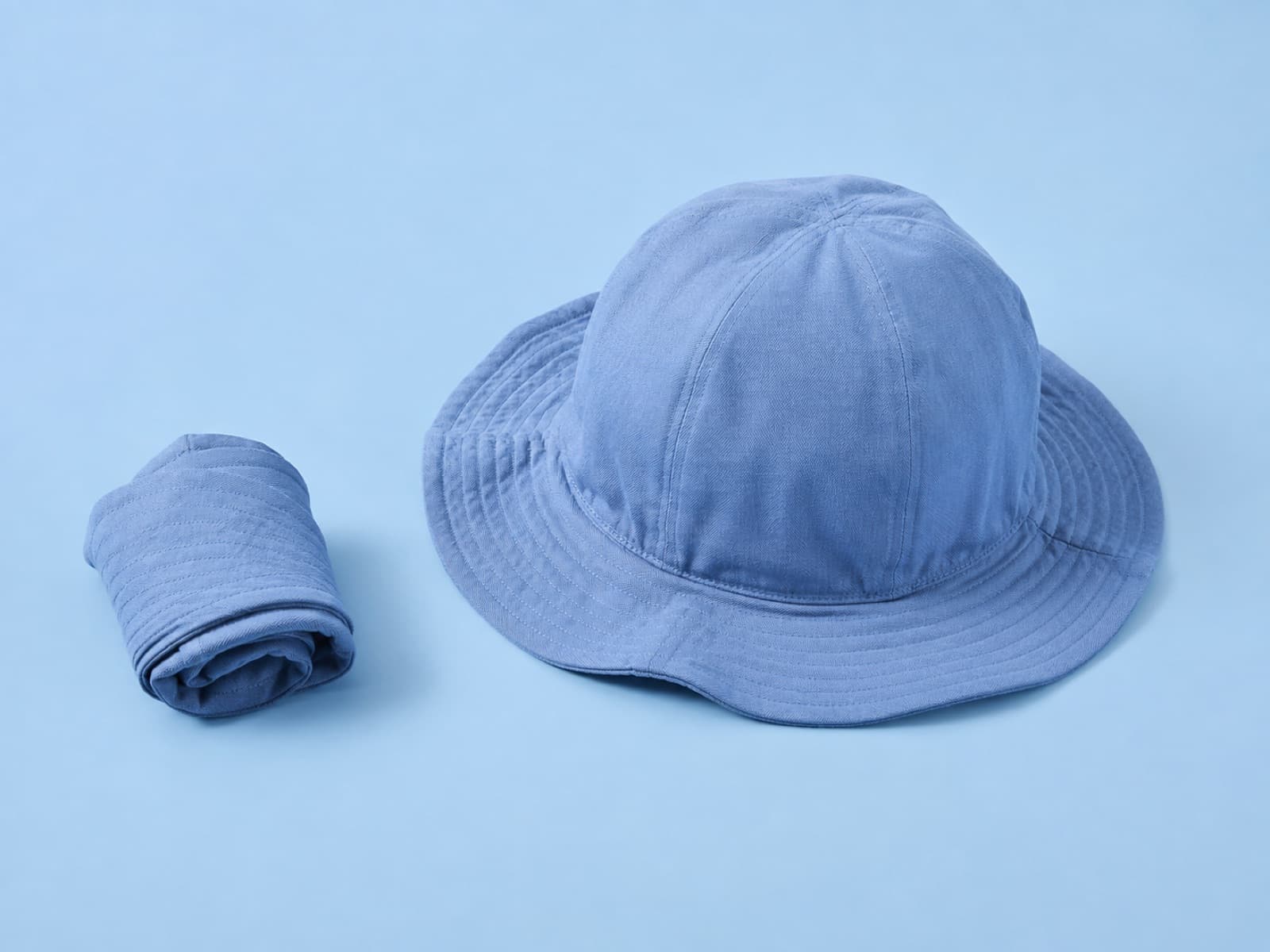 The packable toddler hat rolled up beside the same hat opened out